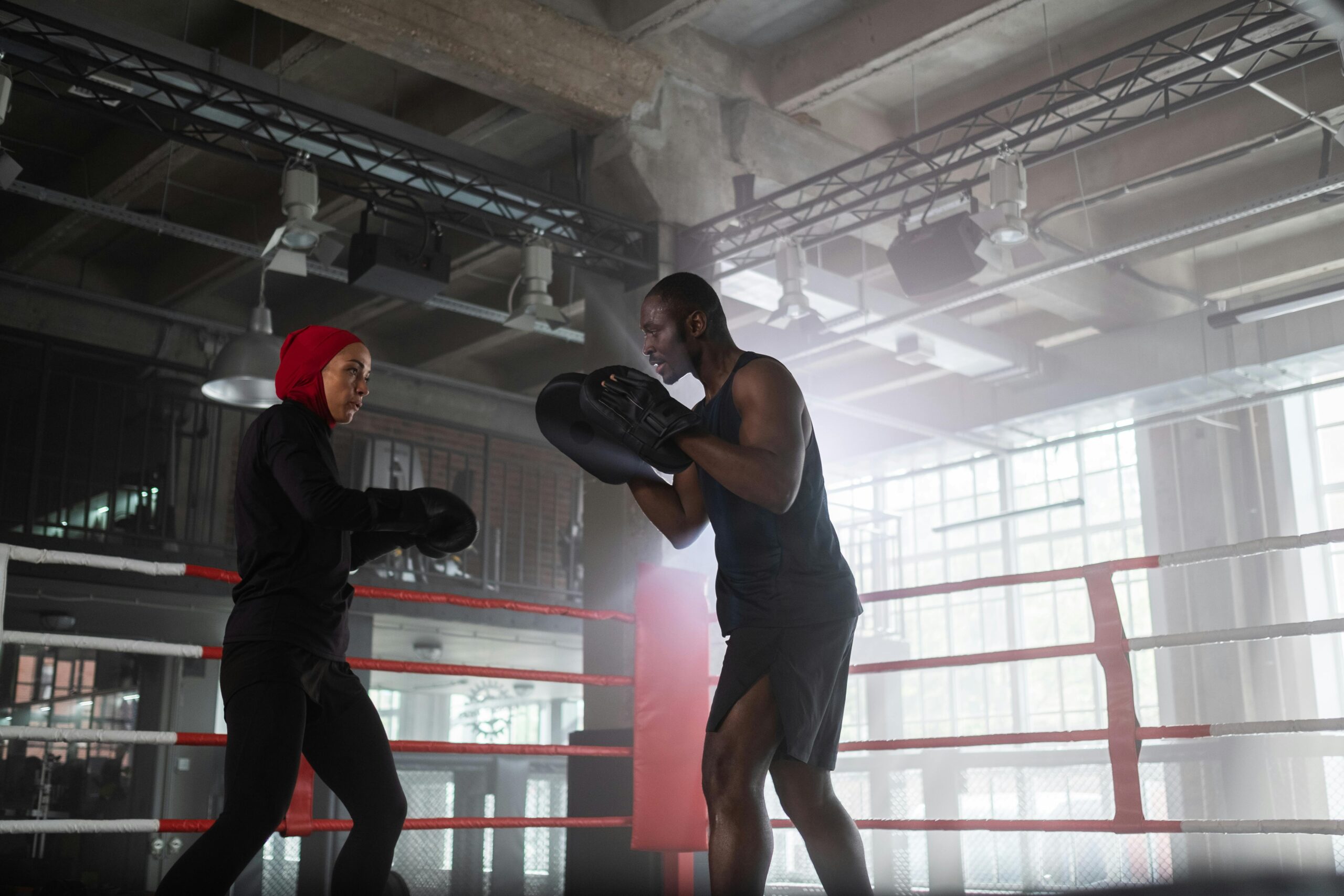 Two boxers sparring in a modern gym, practicing skills and techniques.